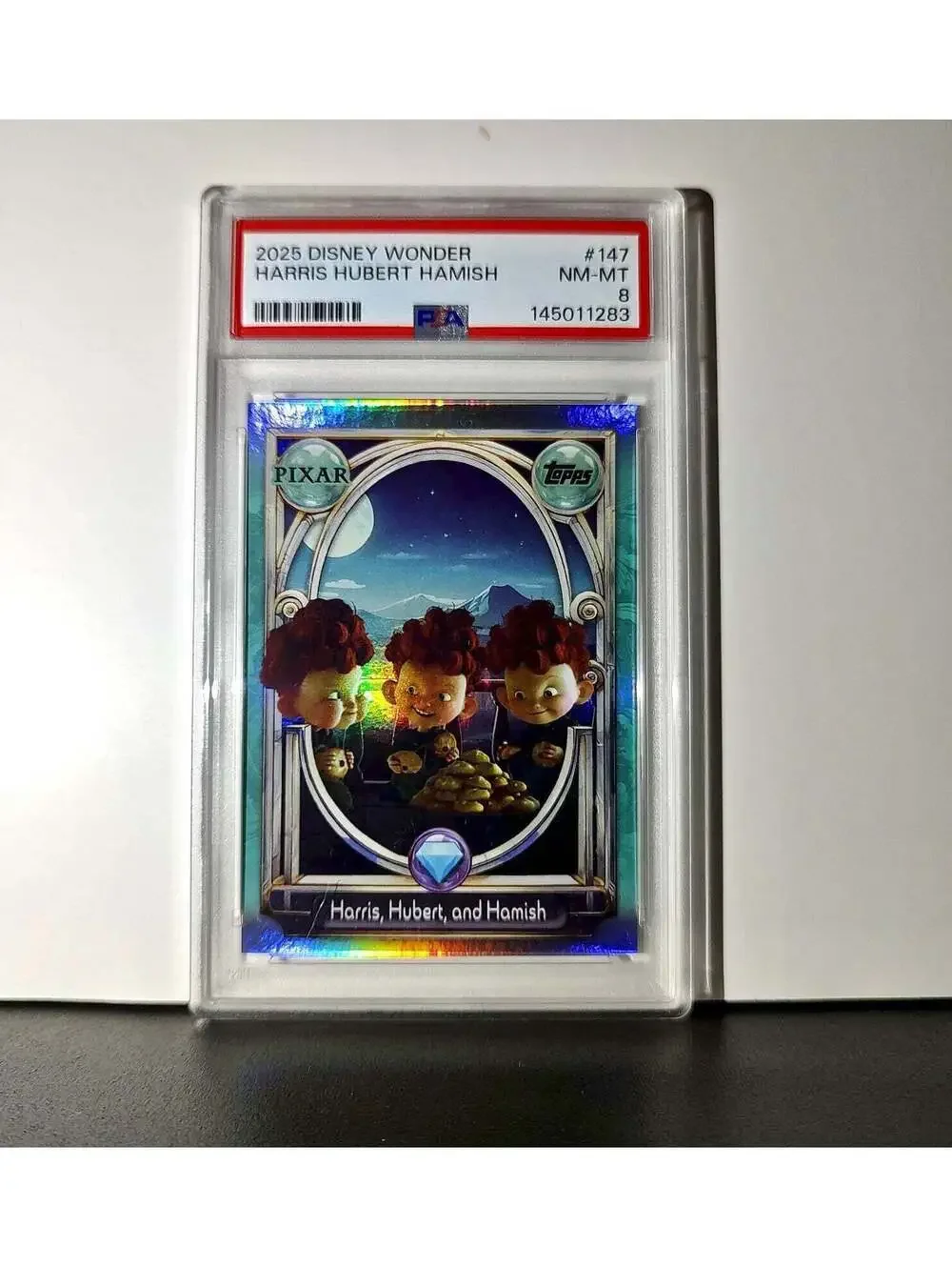 Harris, Hubert, and Hamish 2025 Topps Disney #147 Diamond Card Brave PSA 8